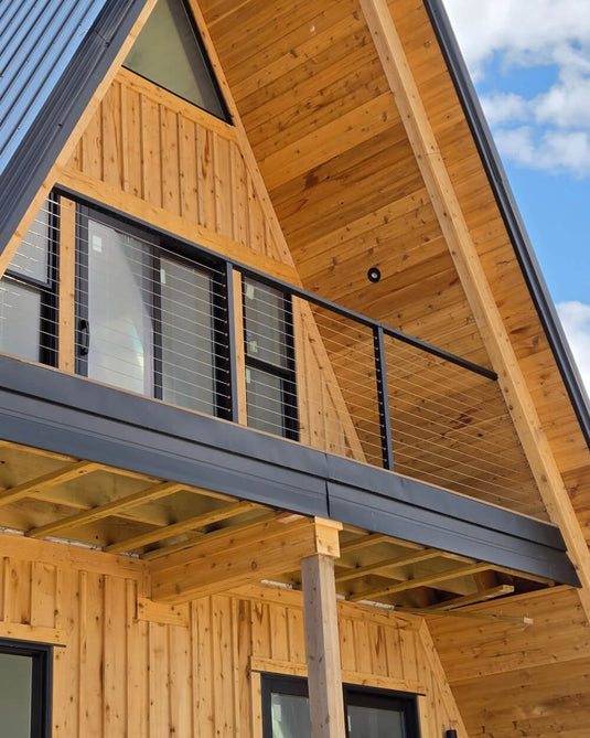 black-cable-railing-on-wooden-balcony-of-a-frame-cabin