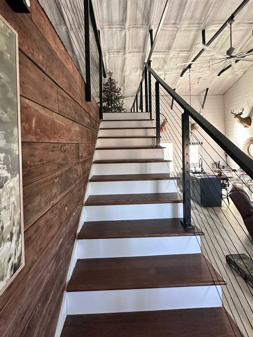 black indoor cable stair railing creating an open look in a rustic modern interior