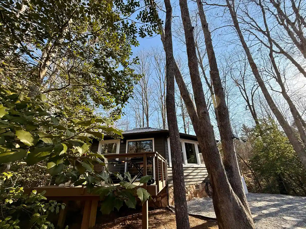 cabin-with-wood-deck-cable-railing-surrounded-by-trees