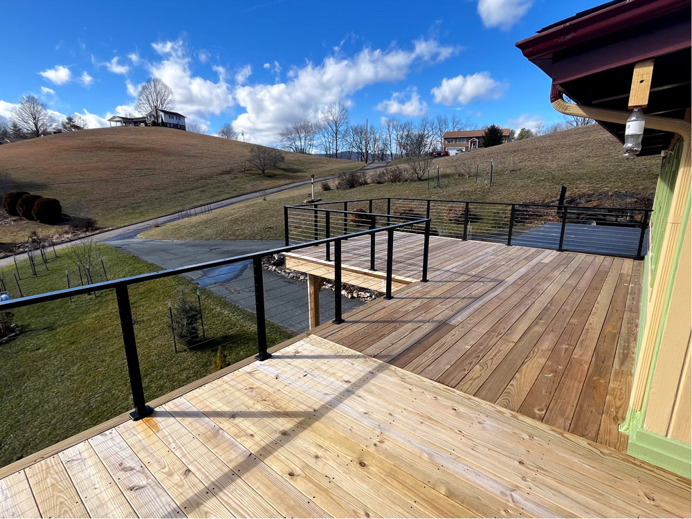corner-view-of-deck-with-wire-deck-railing-and-hillside-scenery