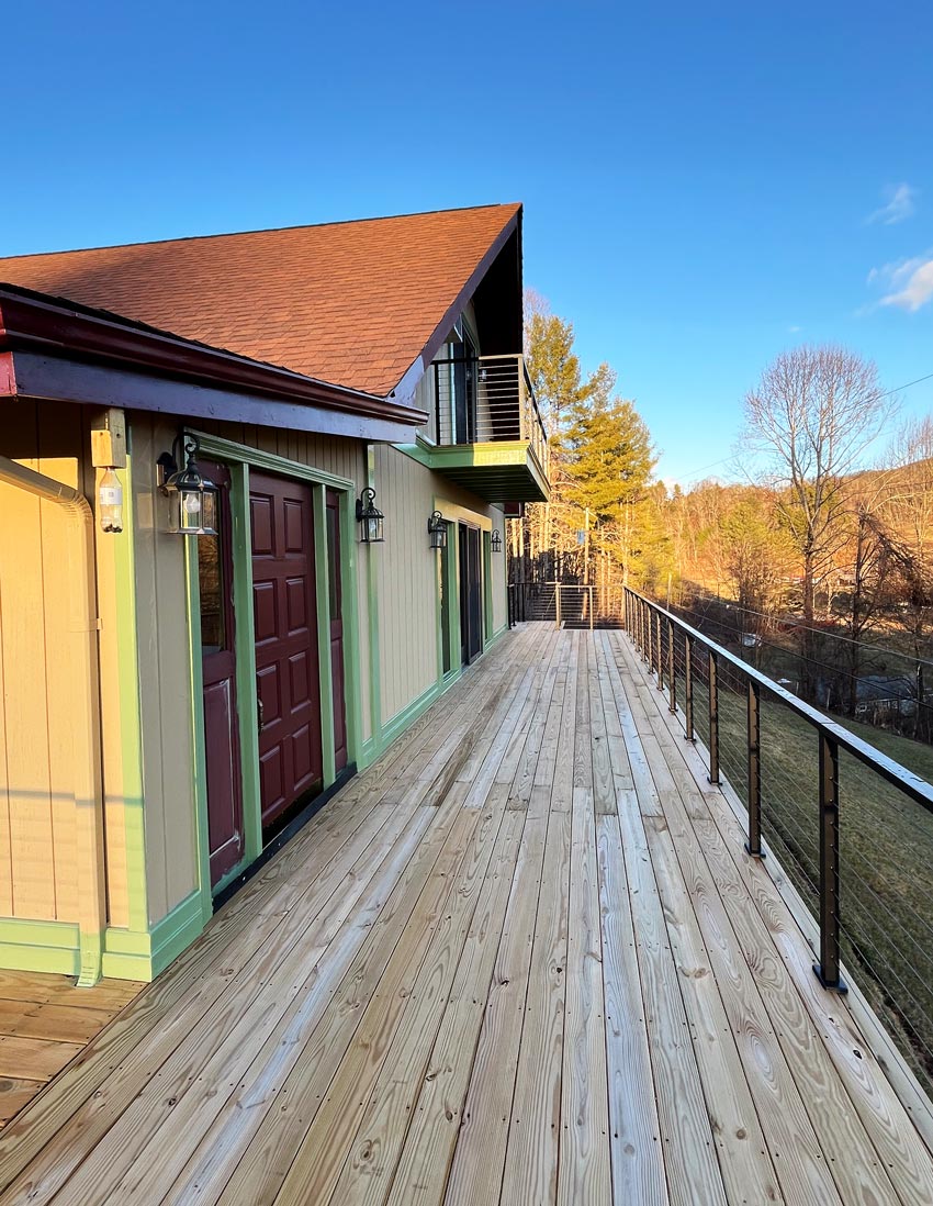 deck-extension-with-wire-deck-railing-and-forest-background