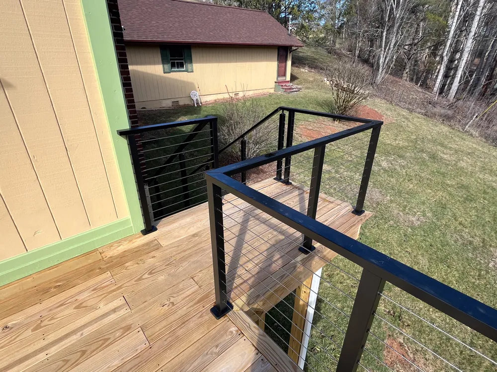 deck-stairs-with-wire-deck-railing-and-grassy-slope