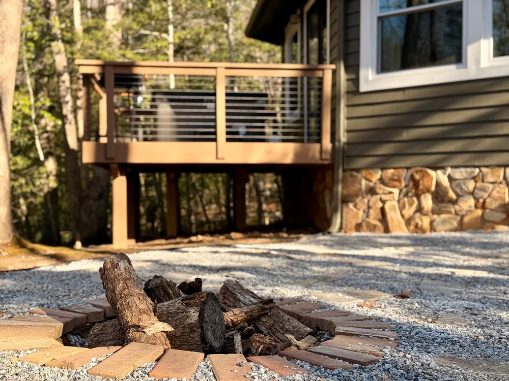 fire-pit-area-below-raised-wood-deck-with-cable-railing