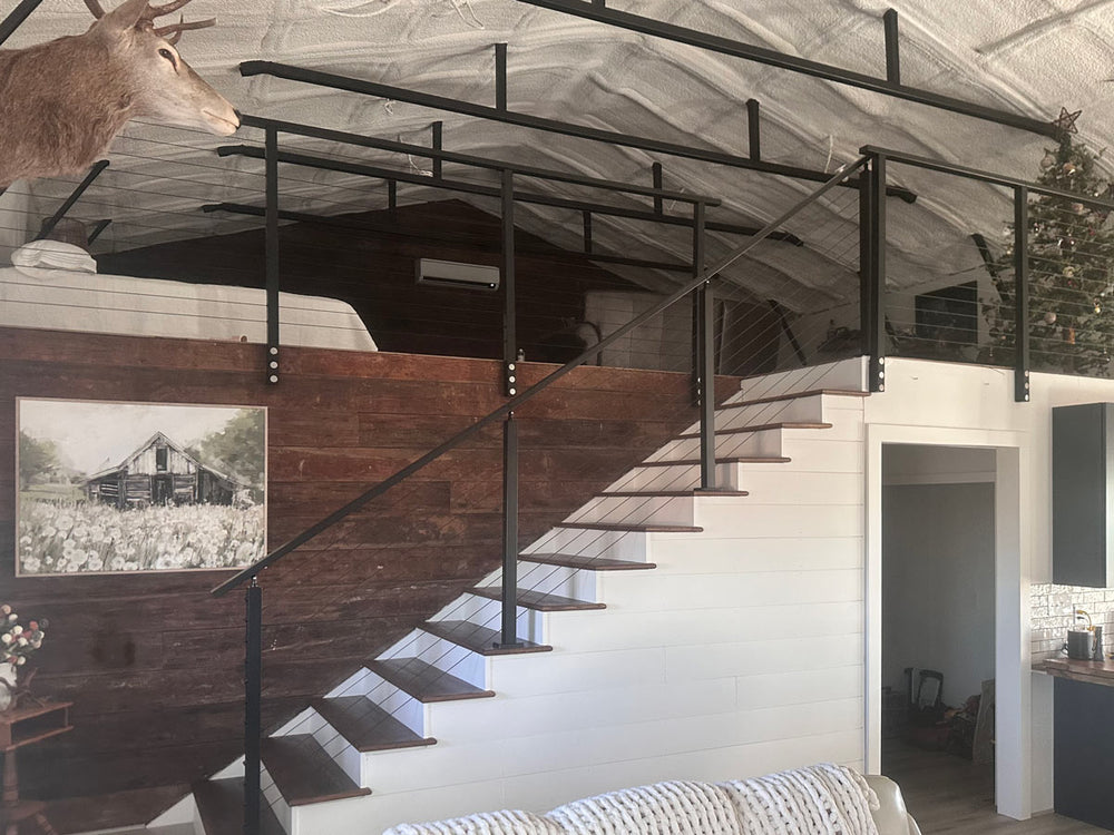 modern indoor cable stair railing connecting the living area to a cozy loft space