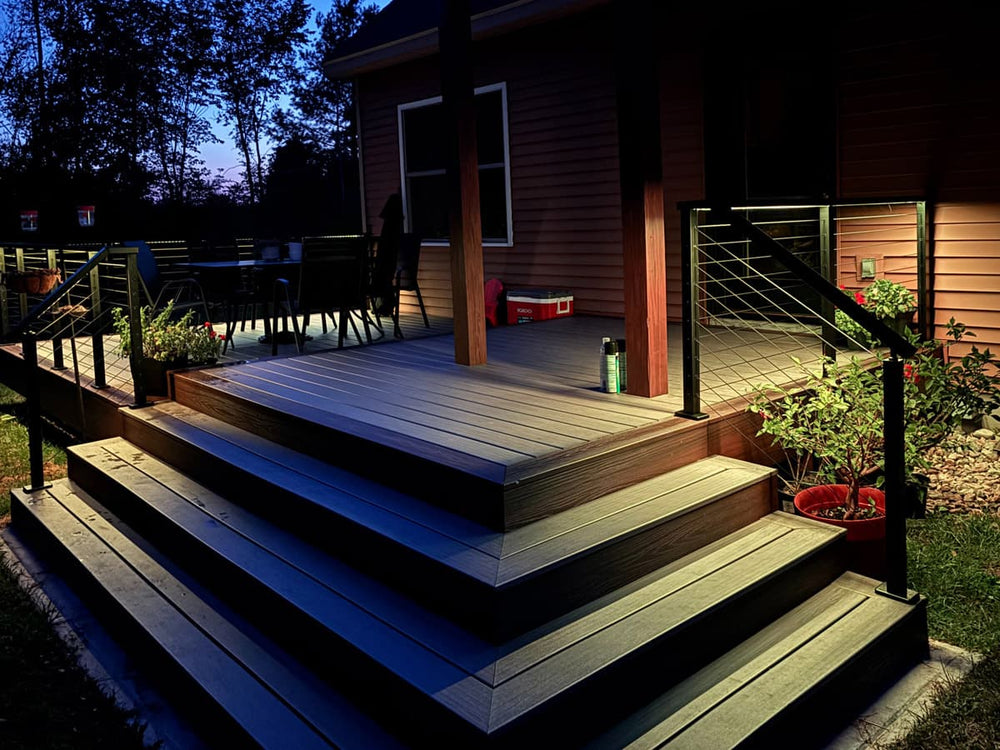 led lit wood deck with black railing at night