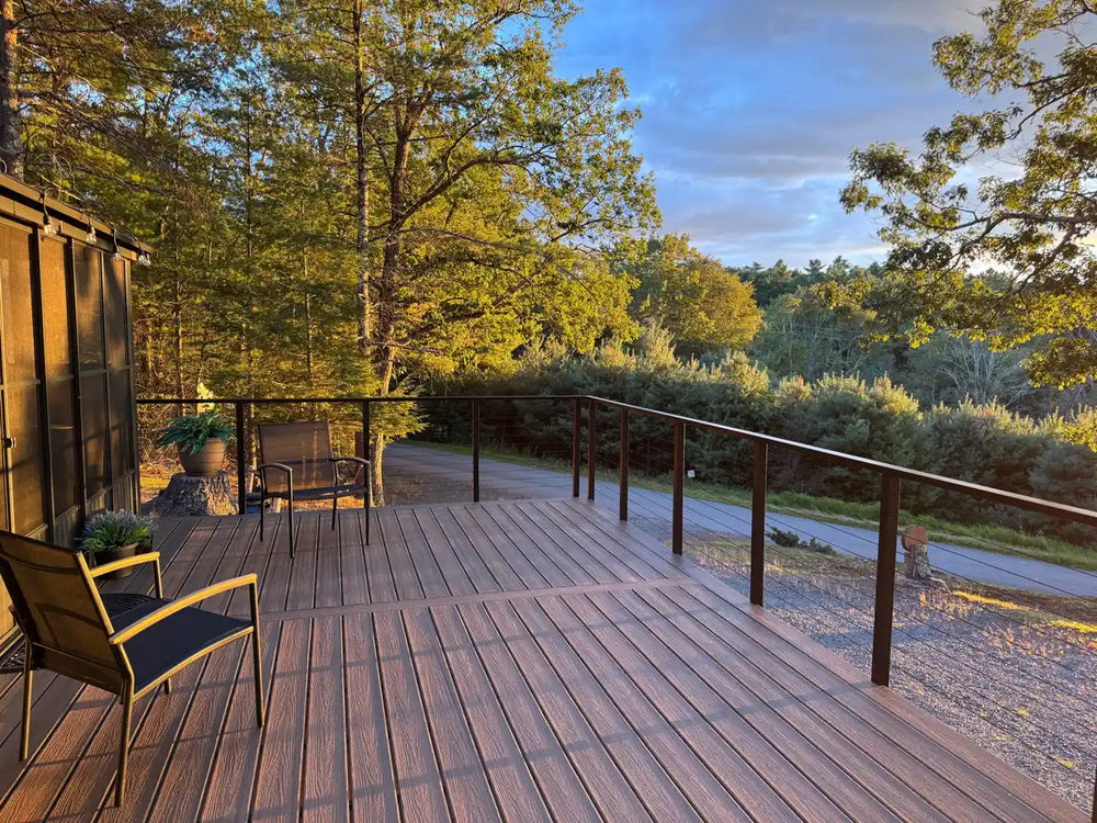 modern deck with black deck railing and outdoor seating surrounded by greenery.