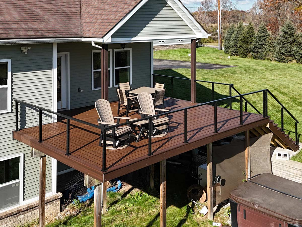 modern deck wire railing on multi level backyard deck with adirondack chairs and dining