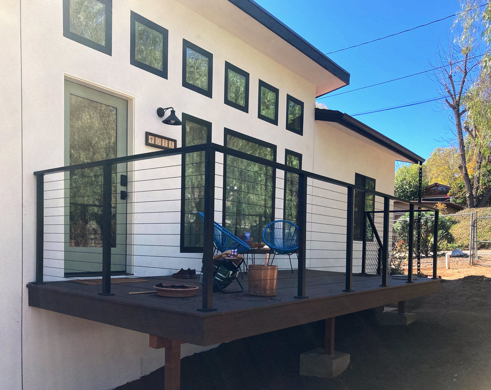 modern home with metal deck railing and outdoor chairs