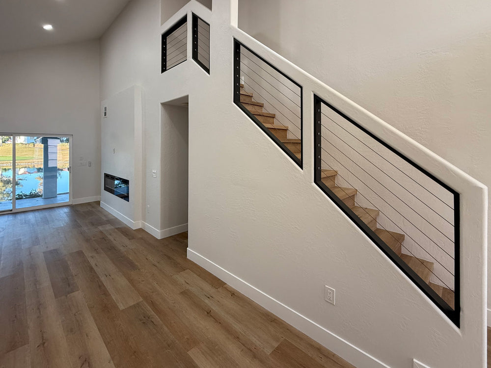 open living space featuring a staircase with black cable stair railing