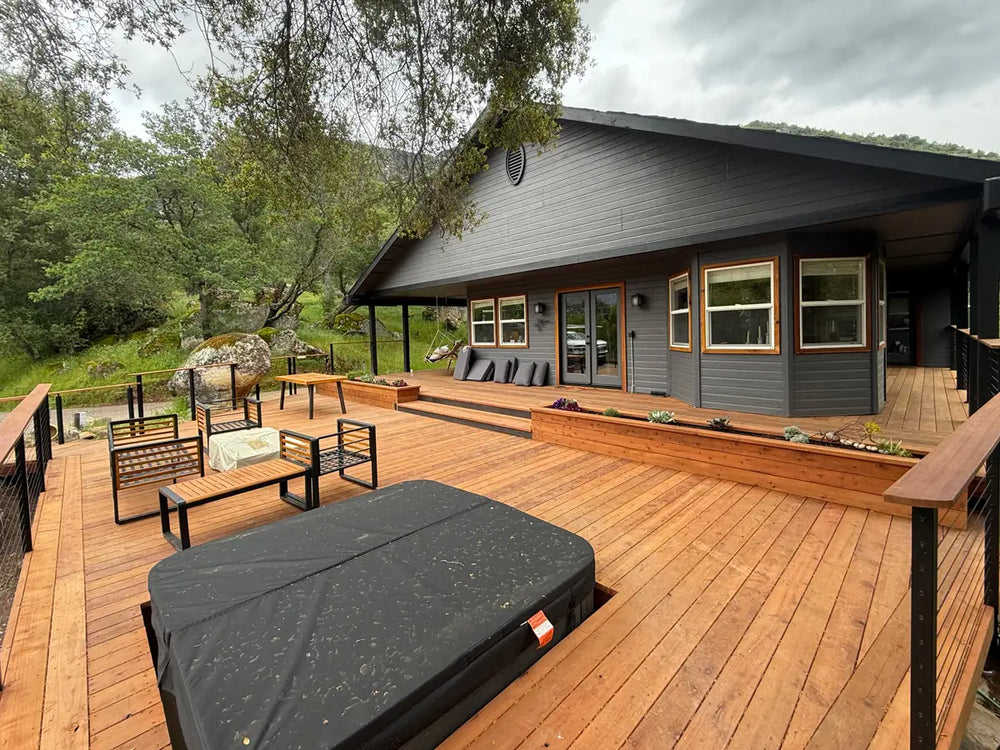 outdoor deck with cable railing for decks, surrounded by trees and rocks