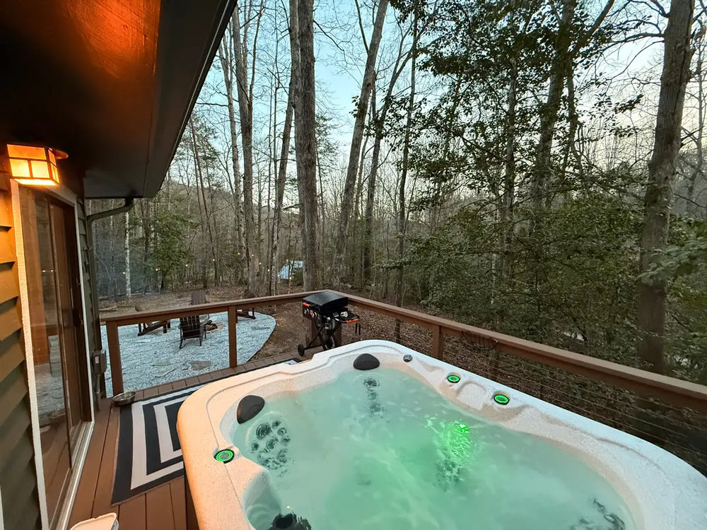 tub-on-wood-deck-with-cable-railing-overlooking-forest